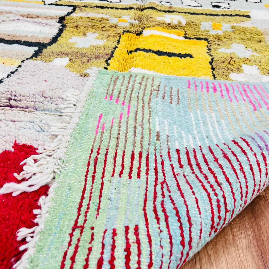 Vintage Moroccan rug with abstract tribal motifs in mustard, red, pink, and blue. Traditional Moroccan Berber rug in vibrant colors.