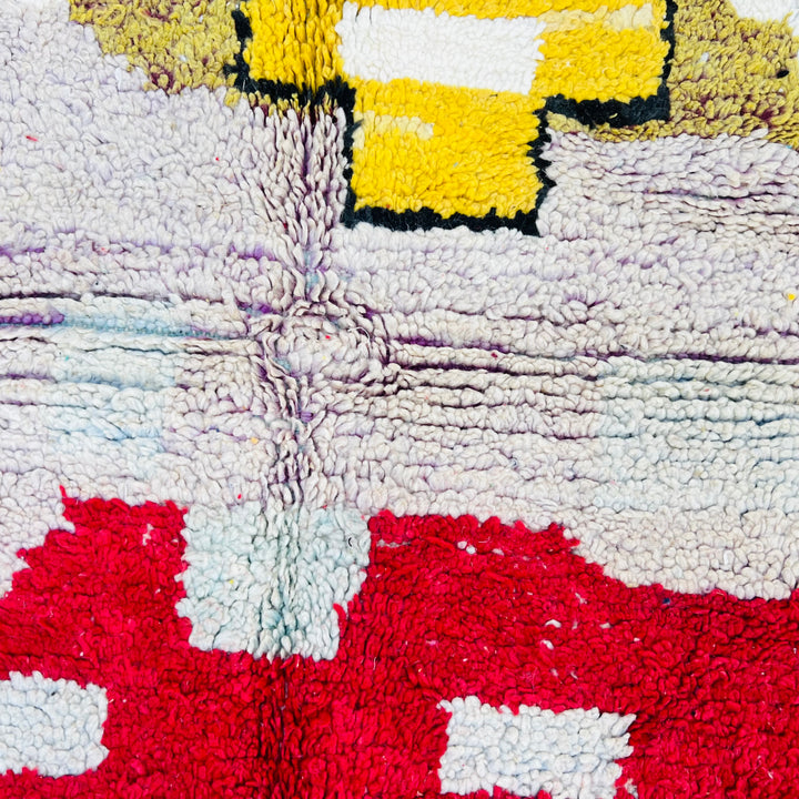 Close-up of a vintage Moroccan Berber rug with abstract tribal patterns in mustard, red, and pastel hues. Rug 428, handmade by artisans.