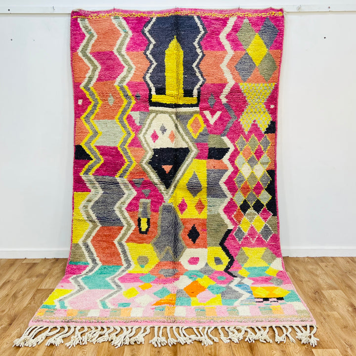 Colorful Moroccan Berber Rug with pink, yellow, black patterns, showcasing traditional tribal symbols, handmade in Morocco.