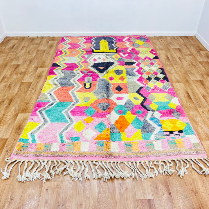 Colorful Moroccan Berber Rug with pink, yellow, coral, and teal tribal patterns, handwoven in Morocco. Perfect for vibrant decor.
