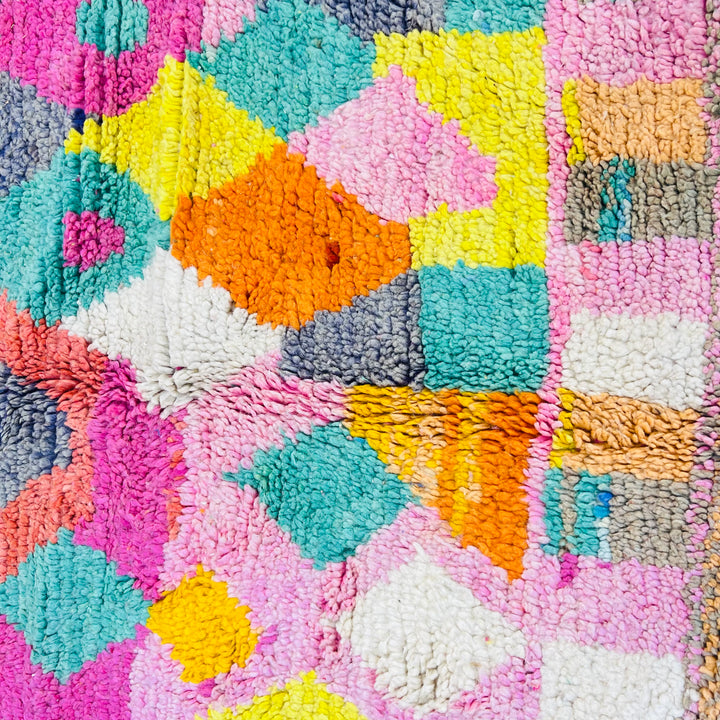 Colorful Moroccan Berber rug with vibrant pink, yellow, teal, and coral tribal patterns. Handmade in Morocco.