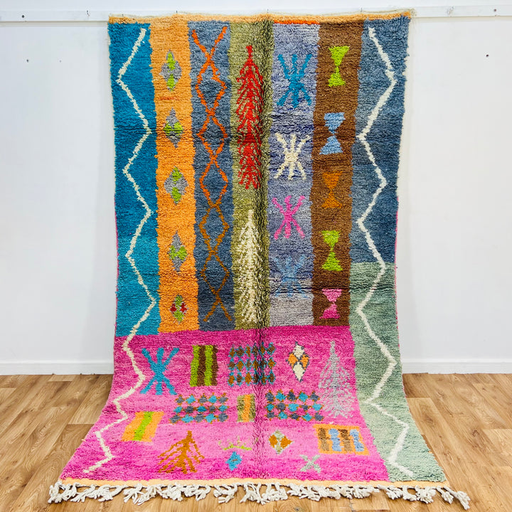 Colorful Berber Moroccan rug with tribal patterns in pink, orange, and blue, handmade with premium wool; 9x5 ft area rug.