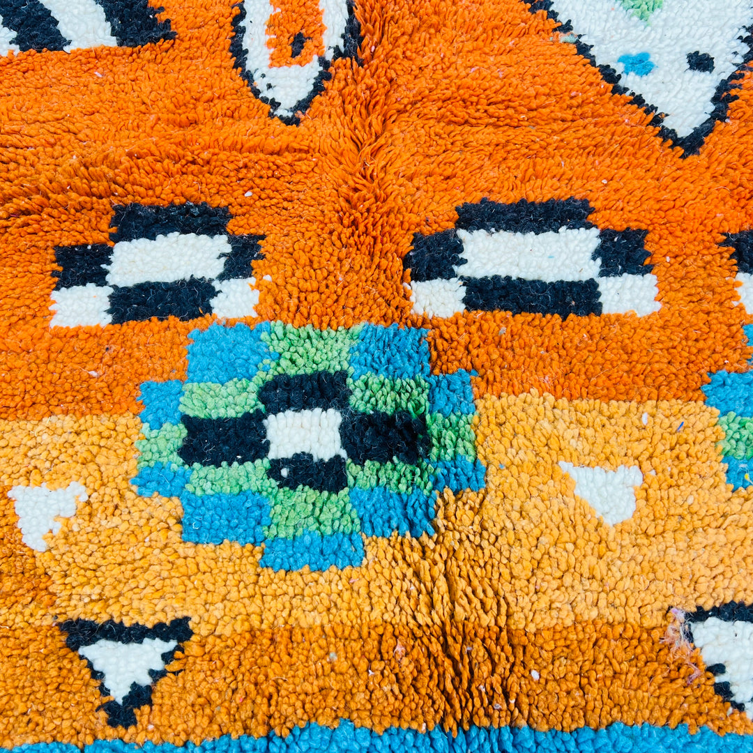 Colorful Moroccan wool rug with bold Berber diamond motifs in hot pink, orange, sky blue, and ivory tones, size 254 x 150 cm.