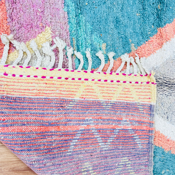Vintage Moroccan wool rug with colorful tribal motifs and fringe detailing.