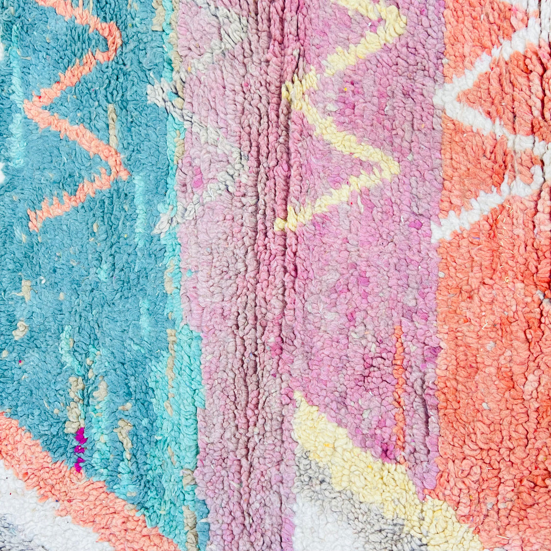 Vintage Moroccan wool rug with vibrant magenta, blue, and orange tribal patterns, handwoven by Berber artisans.