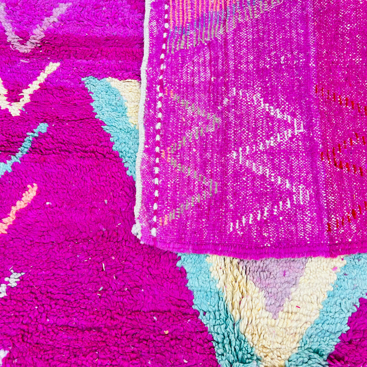 Colorful vintage Moroccan wool rug with V-shaped tribal motifs in magenta, turquoise, orange, pink; handwoven by Berber artisans.