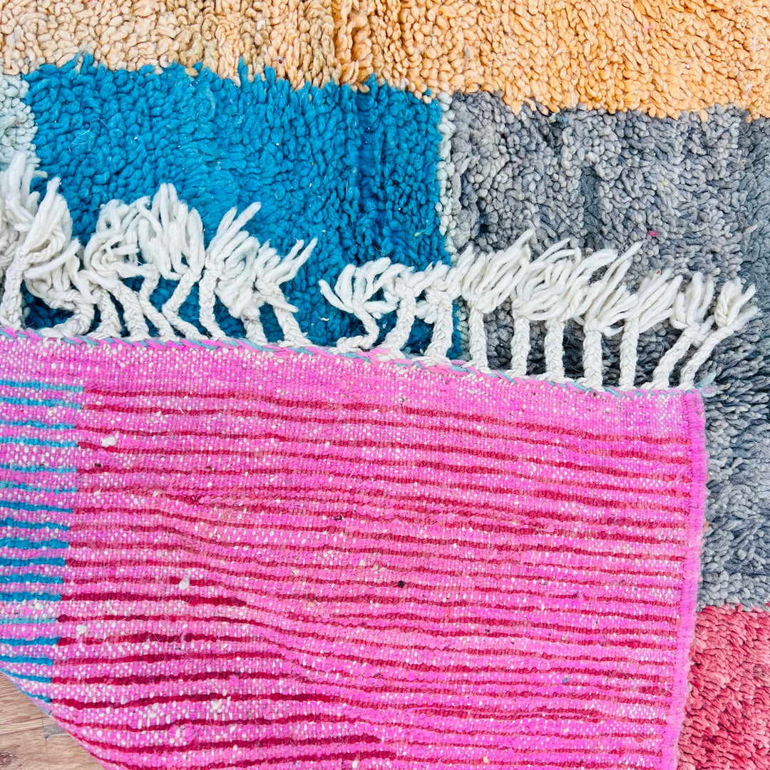 Vintage Moroccan rug with abstract color block design in burnt orange, turquoise, cream, black, and red, woven by Berber artisans.