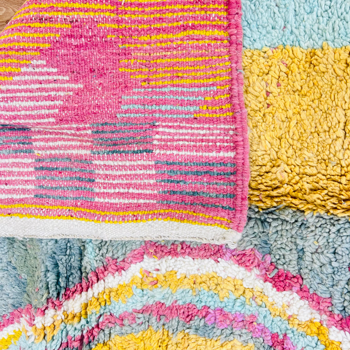 Close-up of a vibrant vintage Moroccan rug with colorful abstract patterns and geometric designs, highlighting its unique texture.