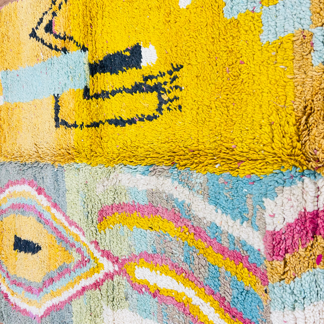 Vintage Moroccan rug with bold abstract tribal design, featuring yellow field with Berber symbols and colorful geometric patterns.