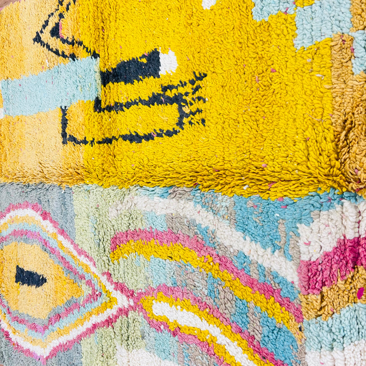 Vintage Moroccan rug with bold abstract tribal design, featuring yellow field with Berber symbols and colorful geometric patterns.