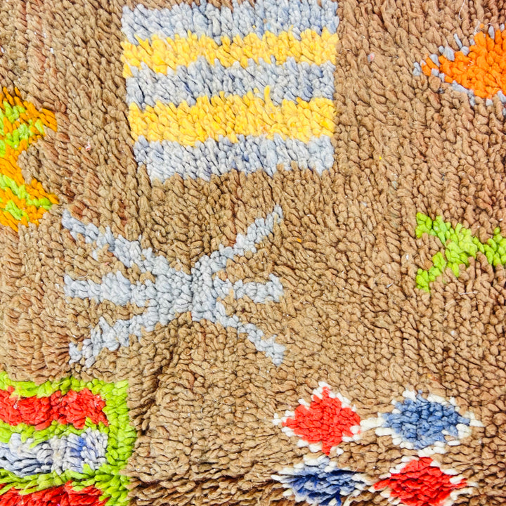 Handwoven vintage Moroccan rug with Berber symbols and earthy tones, featuring colorful abstract patterns, 263 x 150 cm.