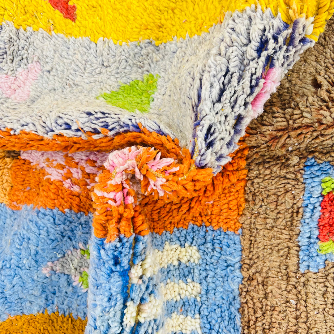Colorful handmade vintage Moroccan rug with vibrant patchwork of Berber symbols in earthy tones. Perfect for adding cultural flair to any room.