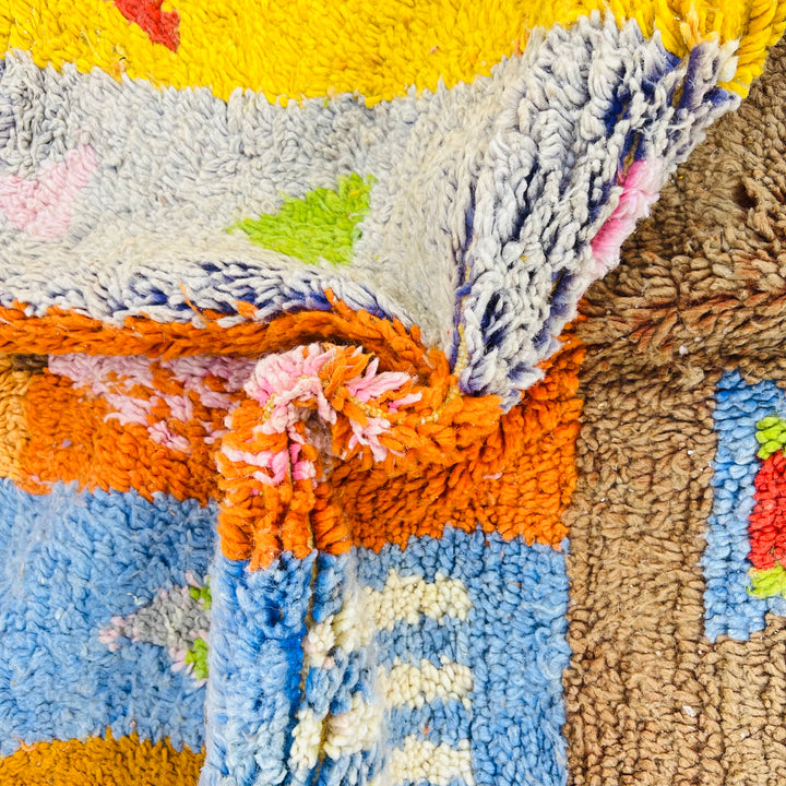 Colorful handmade vintage Moroccan rug with vibrant patchwork of Berber symbols in earthy tones. Perfect for adding cultural flair to any room.