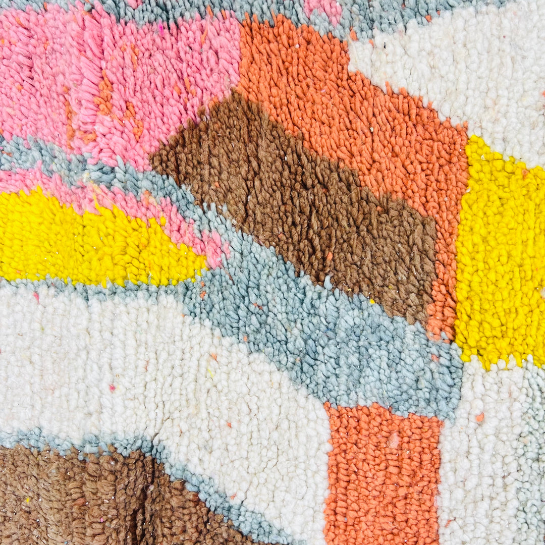Colorful abstract Moroccan rug with geometric patterns in pink, orange, yellow, brown, and cream. Handwoven vintage wool rug.