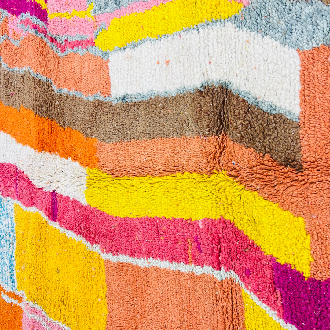 Colorful abstract Moroccan rug with geometric patterns in magenta, turquoise, yellow, for rustic and tribal decor.