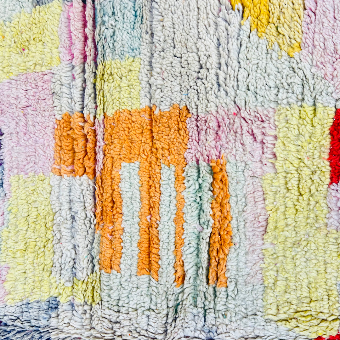 Vintage Moroccan Berber rug with geometric patterns in vibrant colors including purple, yellow, grey, pink, and red, handwoven wool.