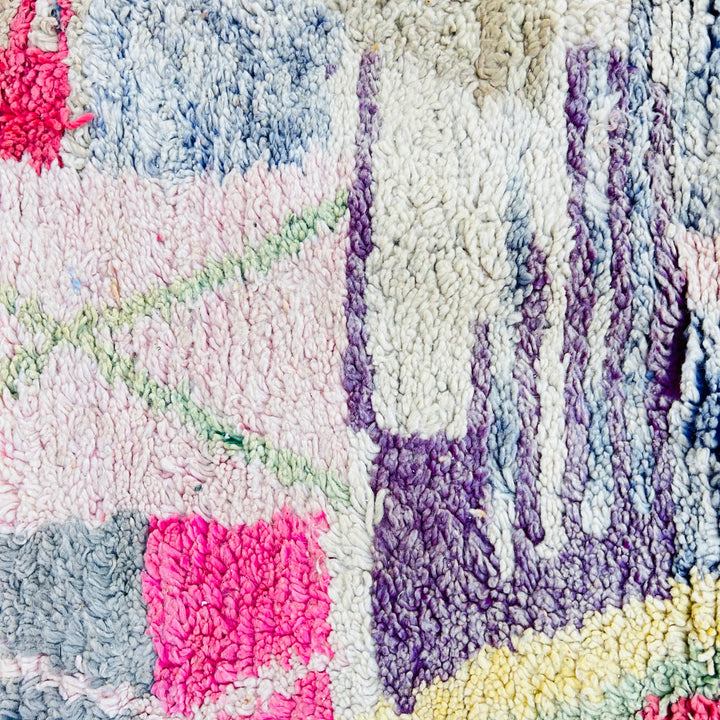 Colorful vintage Moroccan rug with abstract tribal motifs in purple, yellow, grey, pink, and red, handwoven by Berber artisans.