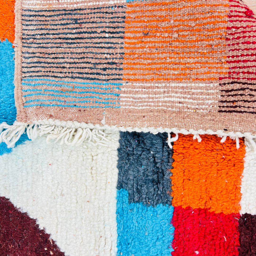 Bold geometric vintage Moroccan rug with rich colors like burnt orange and sky blue, handcrafted from natural wool, traditional Berber design.