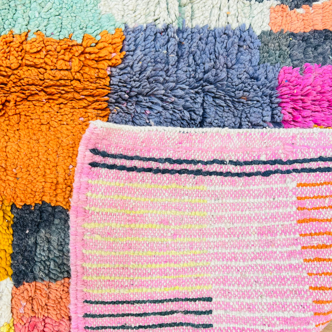 Bold geometric vintage Moroccan rug with vibrant turquoise, mustard, orange, and pink details. Ideal for living rooms or creative spaces.