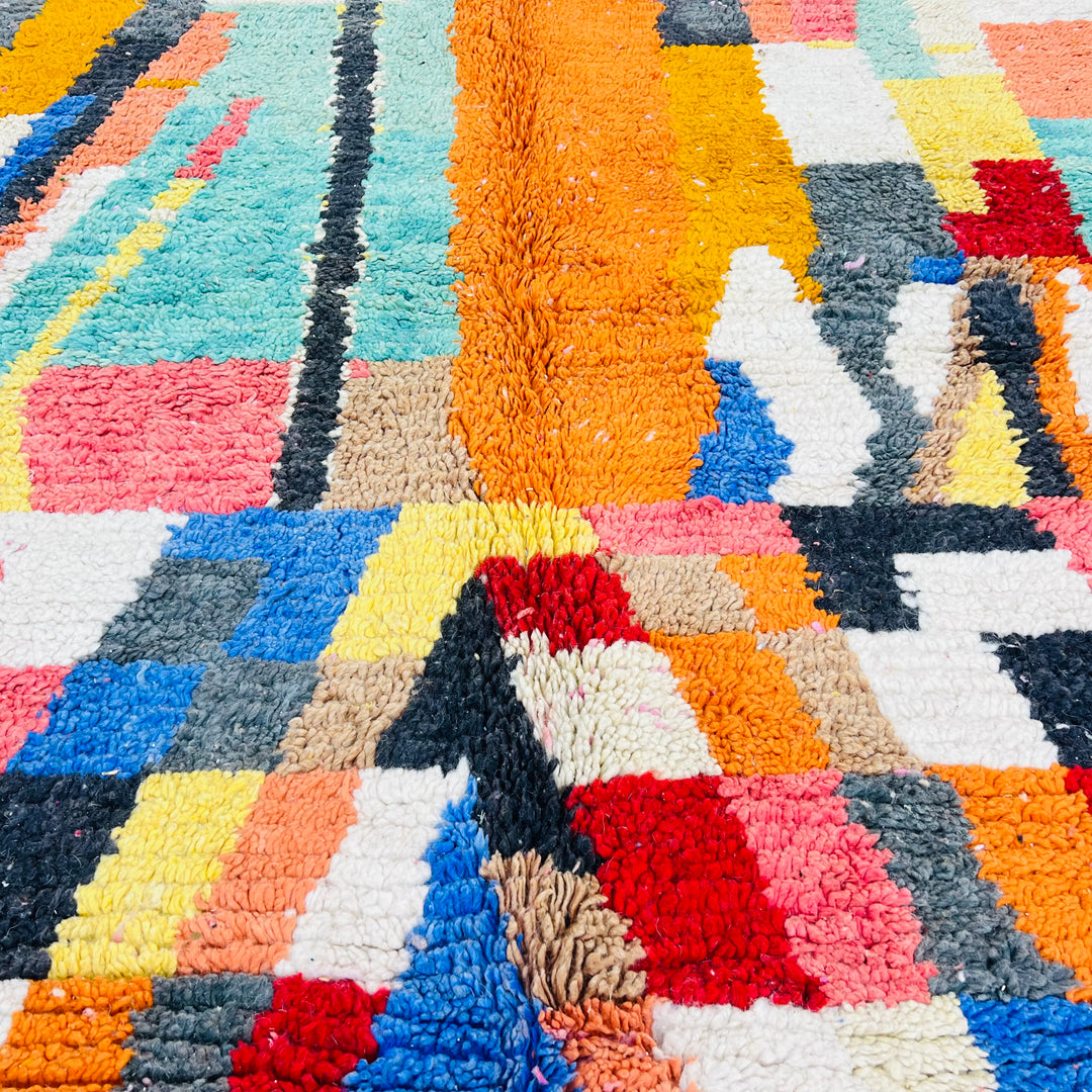 Bold vintage Moroccan rug with geometric patterns in turquoise, yellow, and orange, ideal for living spaces. Moroccan rug for sale.