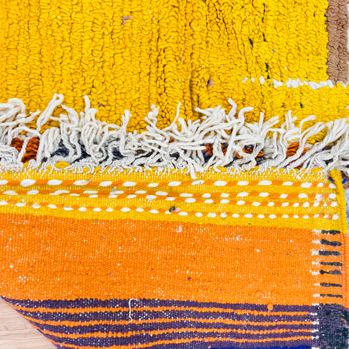 Colorful abstract vintage Moroccan Berber wool rug with yellow and orange geometric patterns, showcasing traditional craftsmanship.