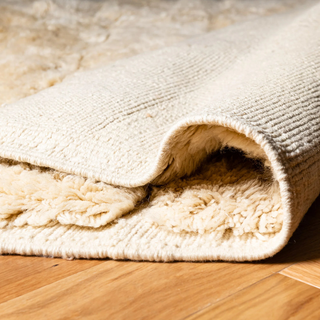 Close-up of Ivory Beni Mrirt Moroccan rug showcasing handwoven wool texture and plush, minimalist design.