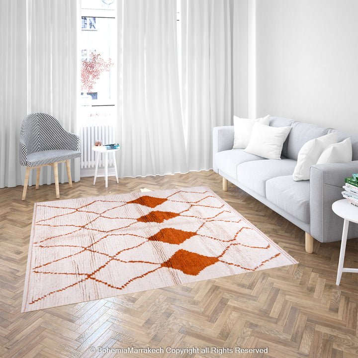 Handmade White Moroccan Rug with Rust Diamonds in a cozy living room setting, featuring a traditional Beni Ourain design.