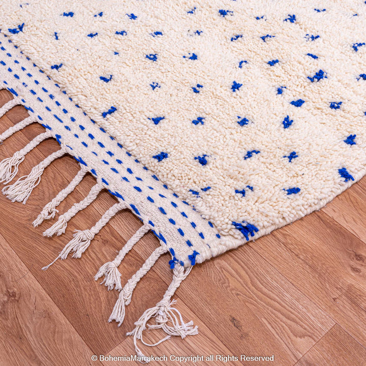 Large white Moroccan wool rug with blue dots, handmade Beni Ourain style, perfect area rug for boho decor, natural fibers.