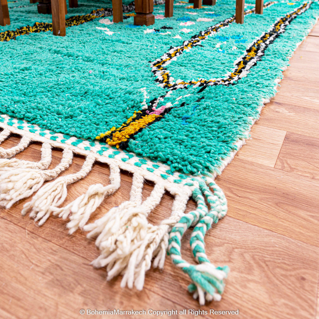 Handwoven green Moroccan Boujad rug with abstract Berber lines and colorful wool symbols