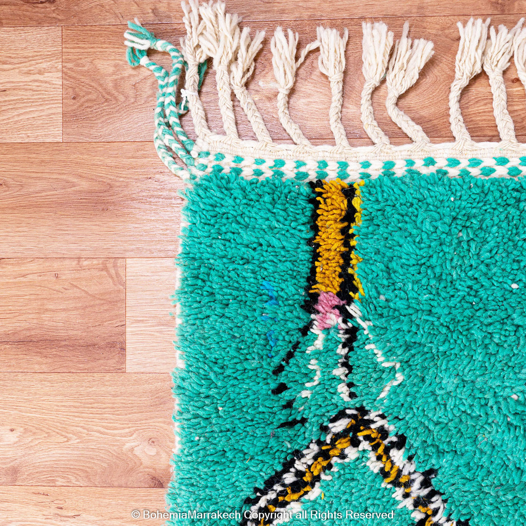Handwoven green Moroccan Boujad rug with abstract Berber lines and colorful wool symbols