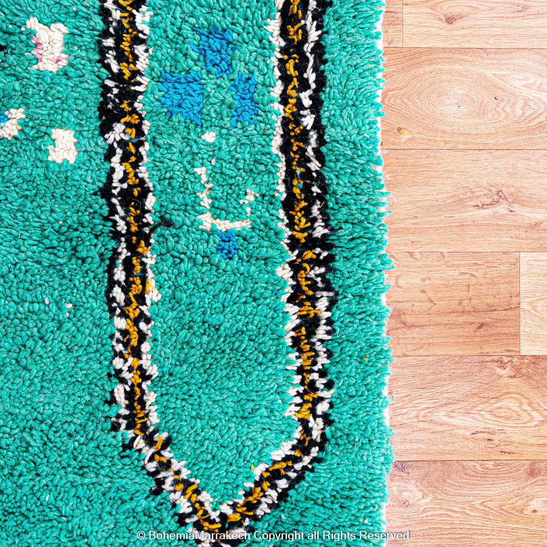 Handwoven green Moroccan Boujad rug with abstract Berber lines and colorful wool symbols