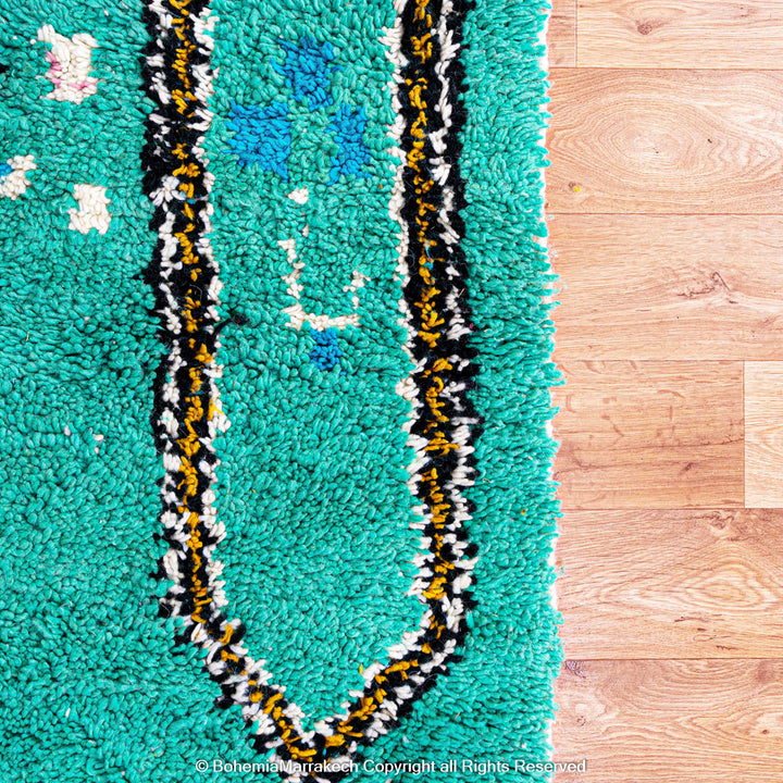 Handwoven green Moroccan Boujad rug with abstract Berber lines and colorful wool symbols