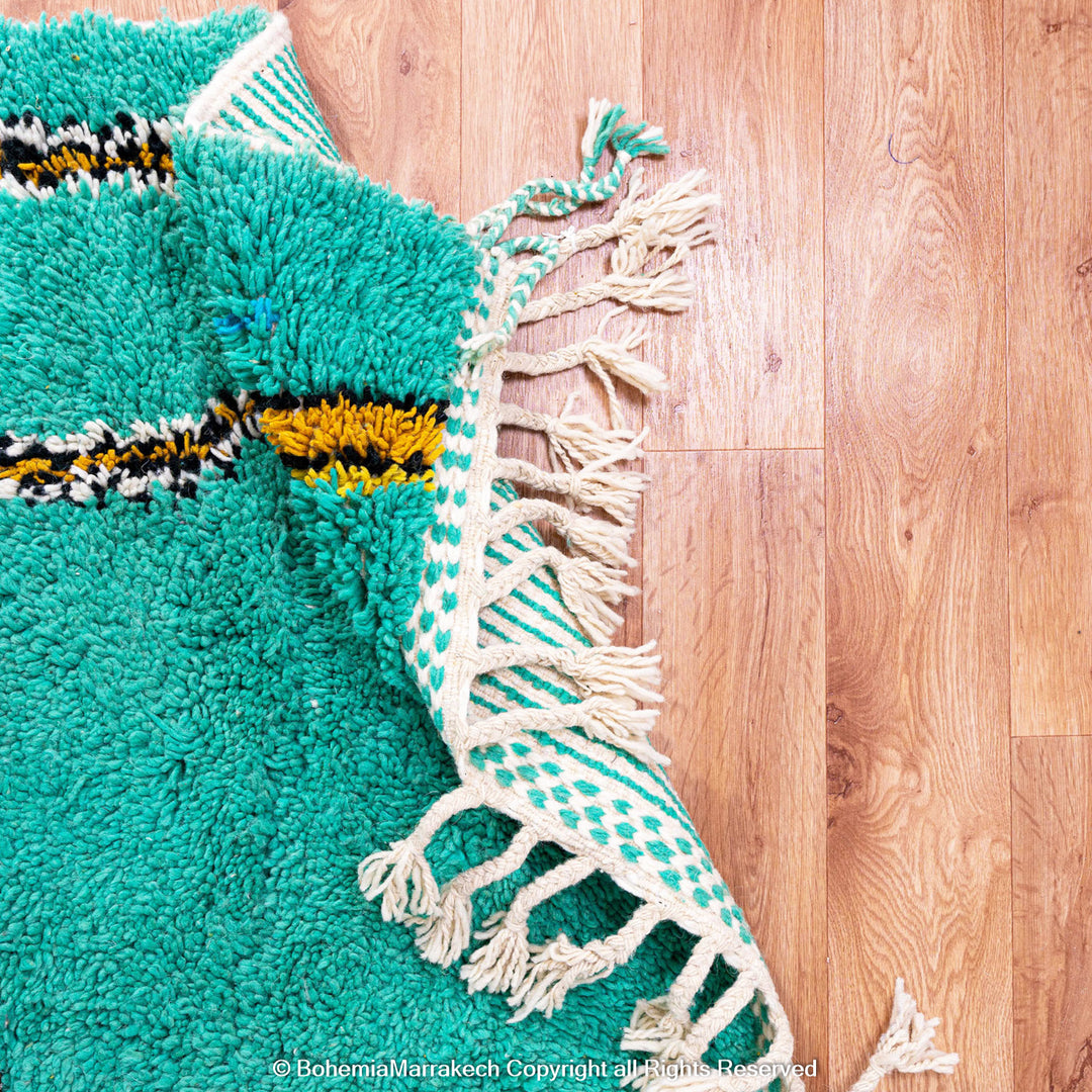 Handwoven green Moroccan Boujad rug with abstract Berber lines and colorful wool symbols