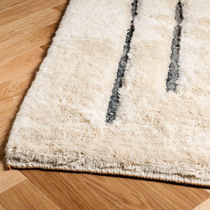 Minimalist Beni Mrirt wool rug with abstract black line design, handwoven by Moroccan artisans