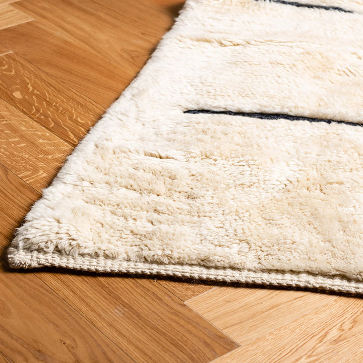 Minimalist Beni Ourain cream rug with black stripes, handmade Moroccan wool rug for Scandinavian or boho interiors.