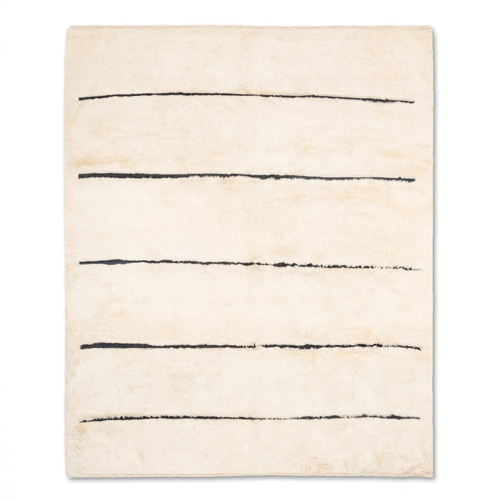 Minimalist Moroccan wool rug with black stripes on cream, handmade by artisans. Perfect for modern interiors. 8x10 area rug.