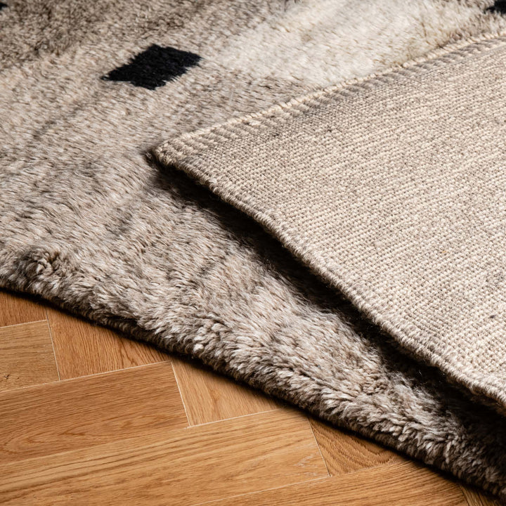 Close-up of minimalist checkered Moroccan rug, handwoven wool with modern geometric design, ideal for contemporary interiors.