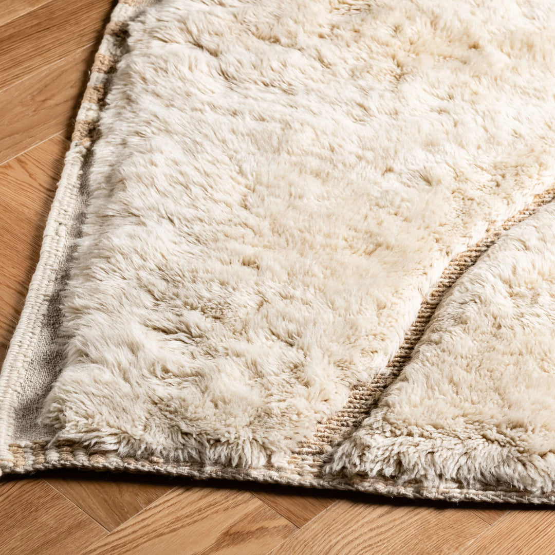 Luxurious Moroccan Beni Mrirt rug in cream, showcasing plush texture on wooden floor; ideal for minimalist and bohemian decor.
