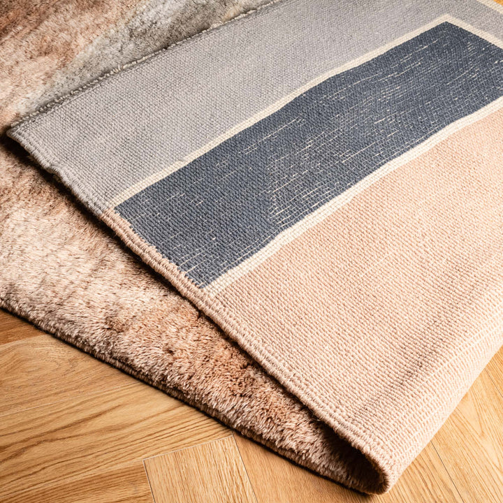Modern Beni Mrirt Moroccan wool rug in soft neutrals with geometric pattern, showcasing peach and slate colors on wooden floor.