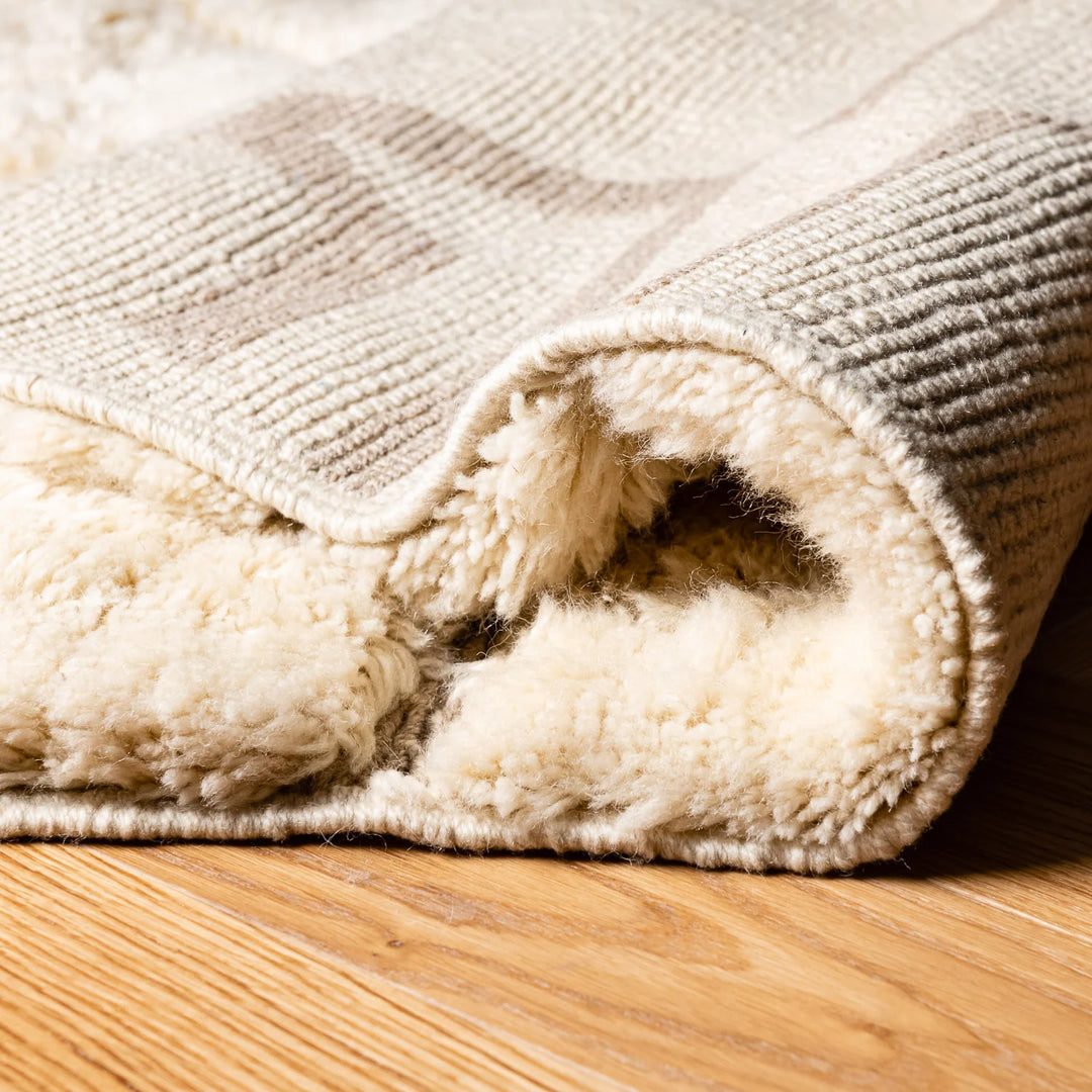 Modern cream Moroccan rug with plush texture, showcasing wool pile. Ideal for minimalist interiors and handmade by Moroccan artisans.