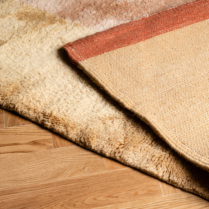 Handwoven Moroccan runner rug with natural wool and Berber pattern on wooden floor, showcasing traditional craftsmanship.