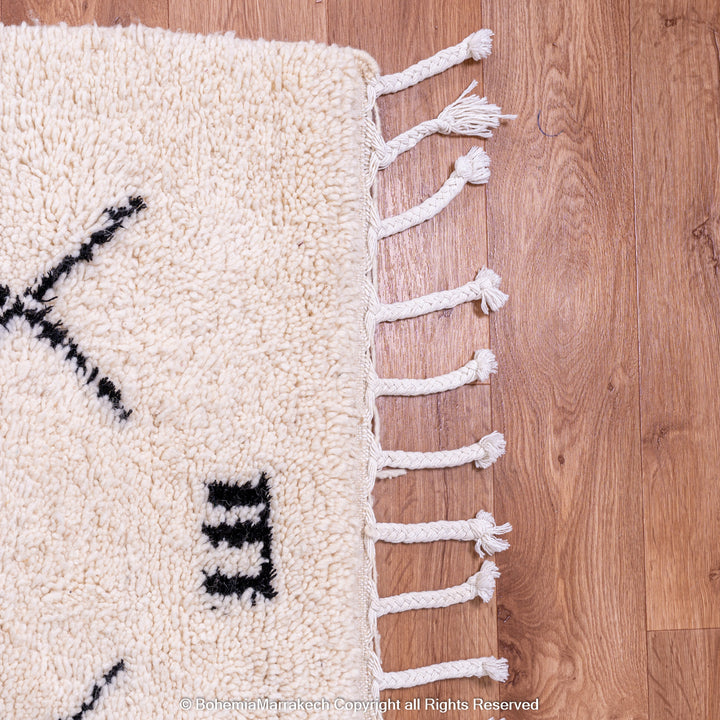 Hand-knotted Beni Ourain Moroccan rug with black tribal diamond patterns on white wool background