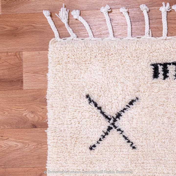 Hand-knotted Beni Ourain Moroccan rug with black tribal diamond patterns on white wool background