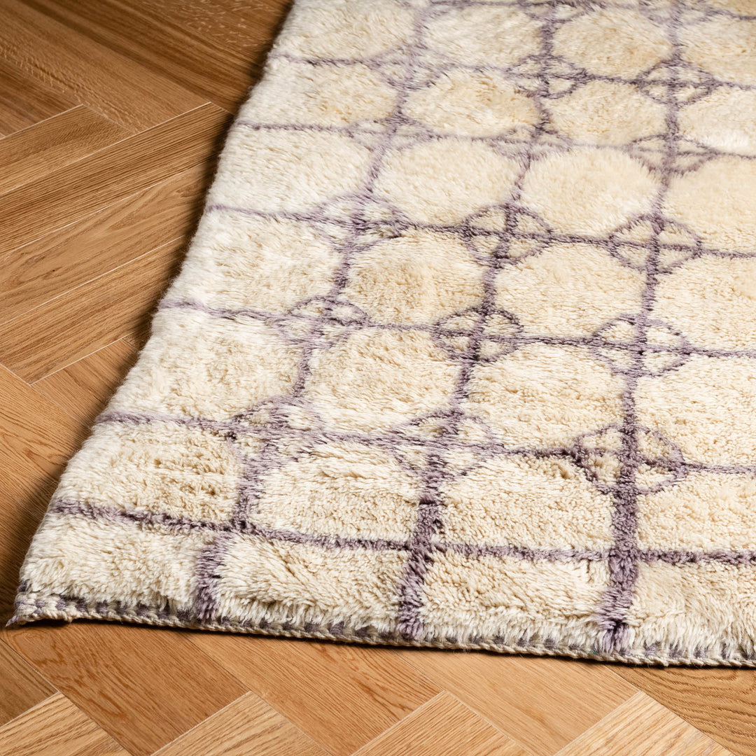 Soft Beni Ourain Moroccan rug with lavender diamond circles on wooden floor