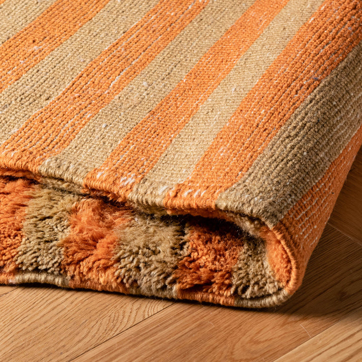Striped Beni Mrirt Moroccan rug in earthy tones, handwoven with premium wool, showcasing vertical stripes on wooden floor.