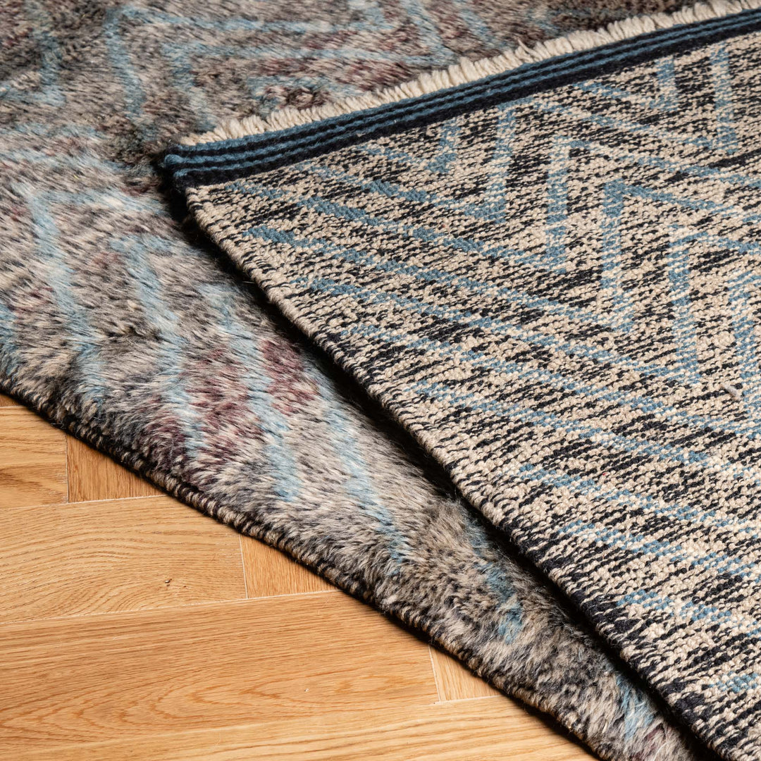 Textured Zigzag Moroccan Rug, handwoven wool style, showcasing blue zigzag pattern and soft plush texture on wood floor.