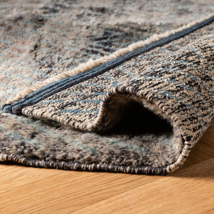 Close-up of a textured zigzag Moroccan rug in earthy tones on a wooden floor, showcasing intricate handwoven wool craftsmanship.