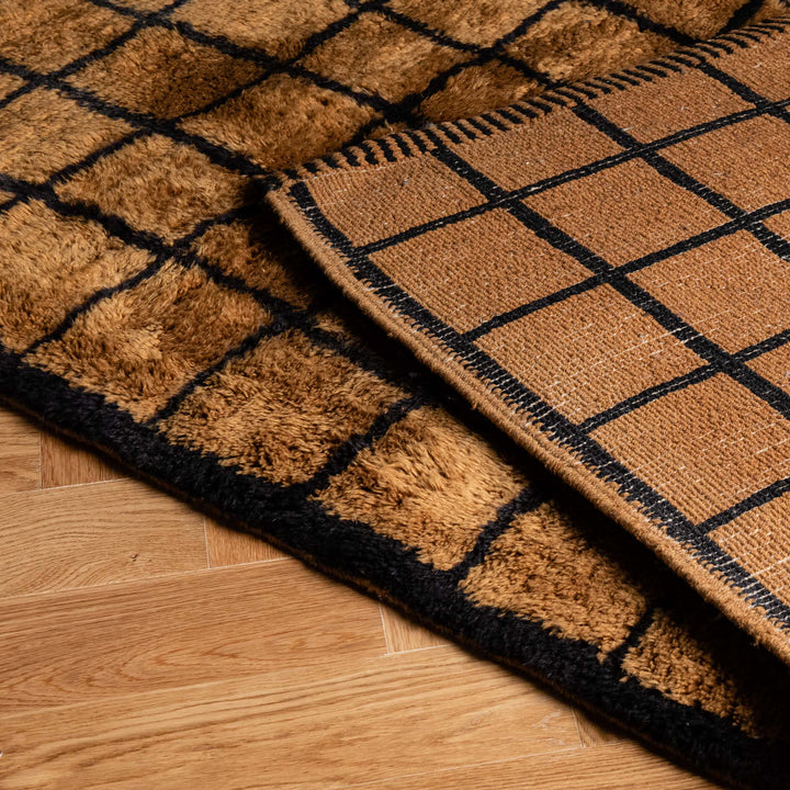 Handwoven Moroccan Berber runner rug in brown and black with a geometric pattern, crafted from natural wool.