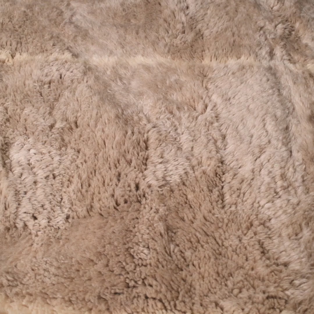 Close-up of beige Beni Ourain Moroccan wool rug with soft Berber patterns, ideal for cozy and elegant home decor.