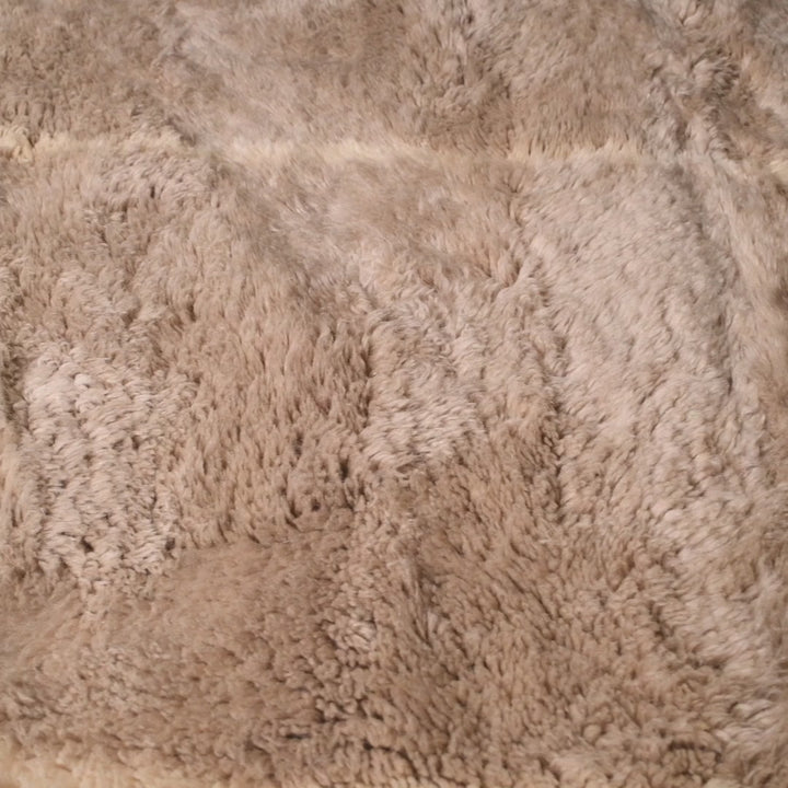 Close-up of beige Beni Ourain Moroccan wool rug with soft Berber patterns, ideal for cozy and elegant home decor.